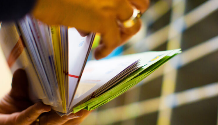 A photo of hands flipping through mail.