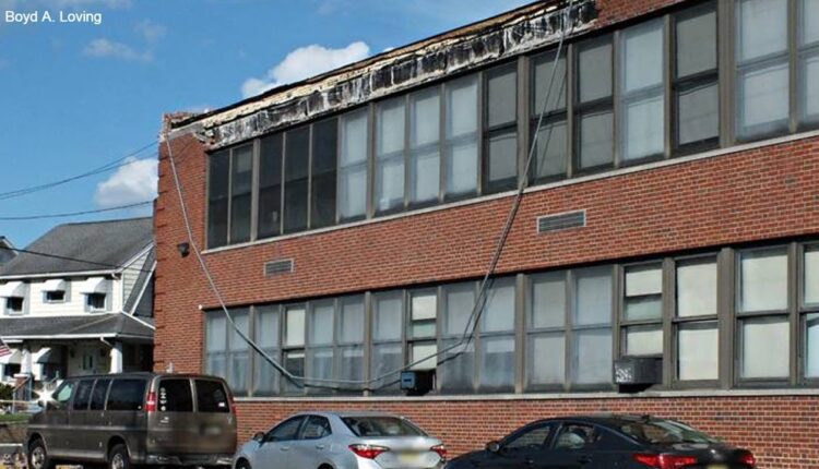 Section of brick wall on top of NJ high school collapses down below