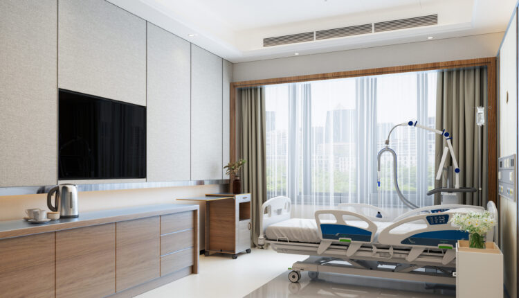 A photo of the interior of a luxury hotel room. The room features a flat screen TV, an electric kettle, and a bouquet of flowers.